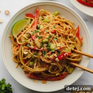 Square image of a bowl with noodles and vegetables on a white background, clean and appealing.