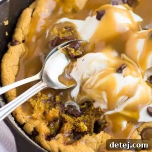 skillet cookie with caramel and ice cream with spoons.