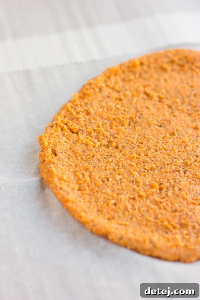 pre-cooked sweet potato pizza crust on parchment paper.