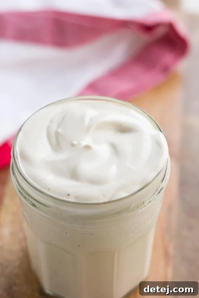 Plant-Based Mayo 7 vegan mayo in a glass jar with red towel in background.