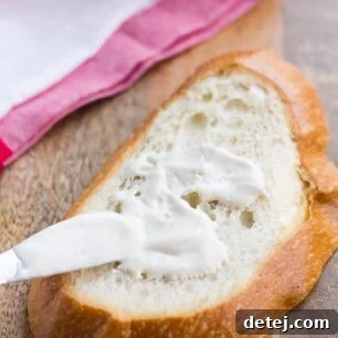 Plant-Based Mayo 8 vegan mayo being spread on a piece of bread with a towel in background.