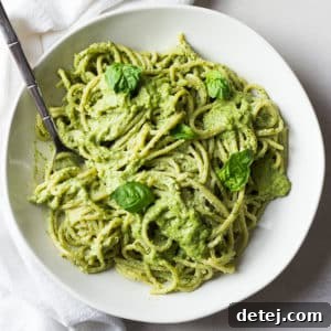 square image of pesto with noodles in a bowl