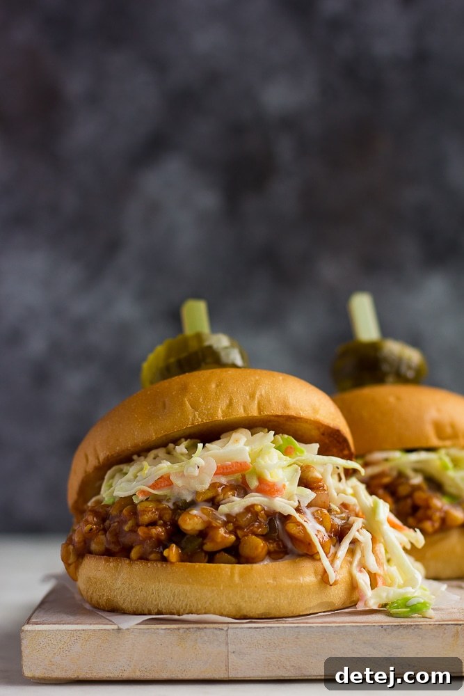 Delicious BBQ tempeh sandwich topped with pickles, ready to eat.