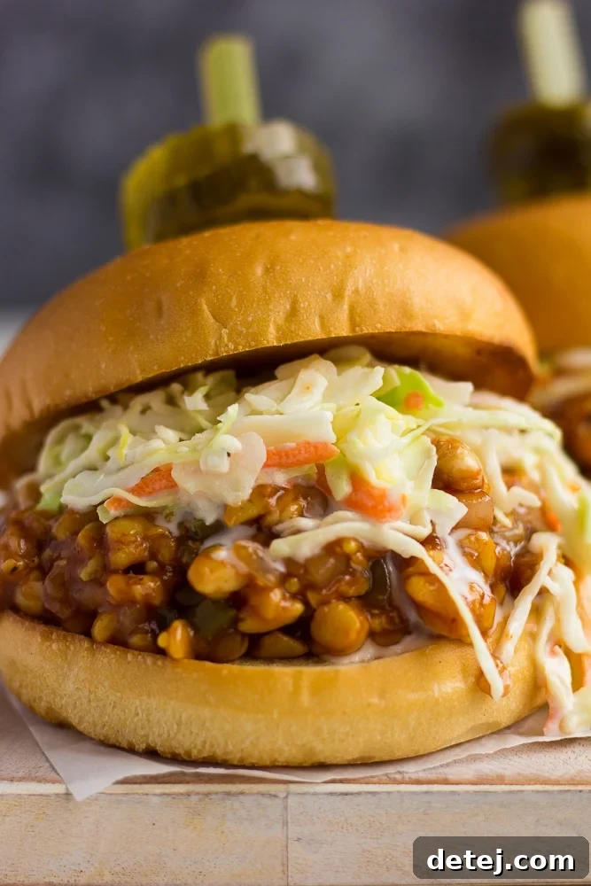 Close-up view of a hearty BBQ tempeh sandwich with fresh ingredients.