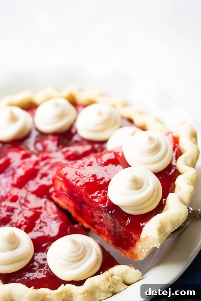 slice of strawberry pie being lifted out of pie plate.