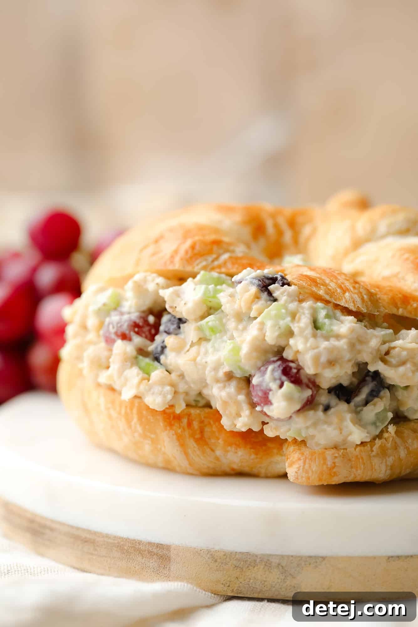 close up on vegan chicken salad in a croissant sandwich.