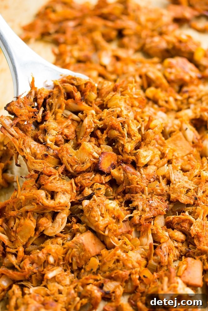 spatula lifting out carnitas from pan