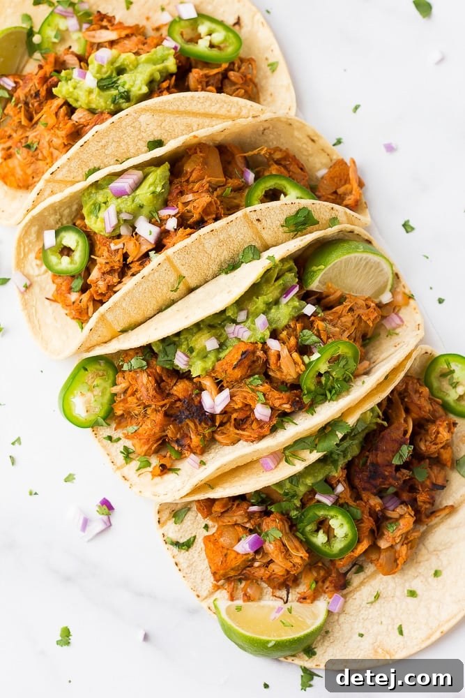 carnitas tacos lined up in a row