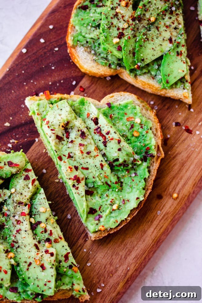 avocado toast on cutting board with red chili flakes