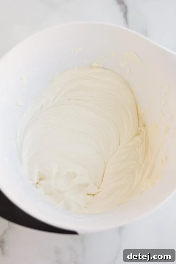 the white frosting for pumpkin cookies in a bowl, whipped to perfection.