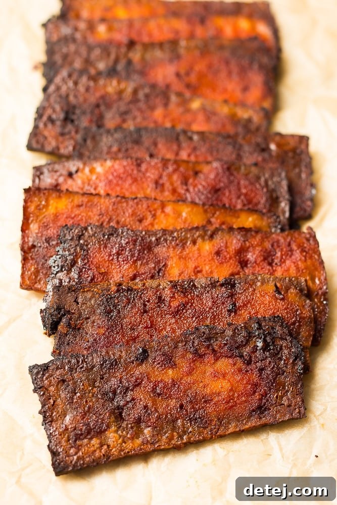tofu bacon stacked in a row on parchment paper