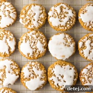 A collection of beautifully iced vegan oatmeal cookies on a cooling rack, ready to be enjoyed.