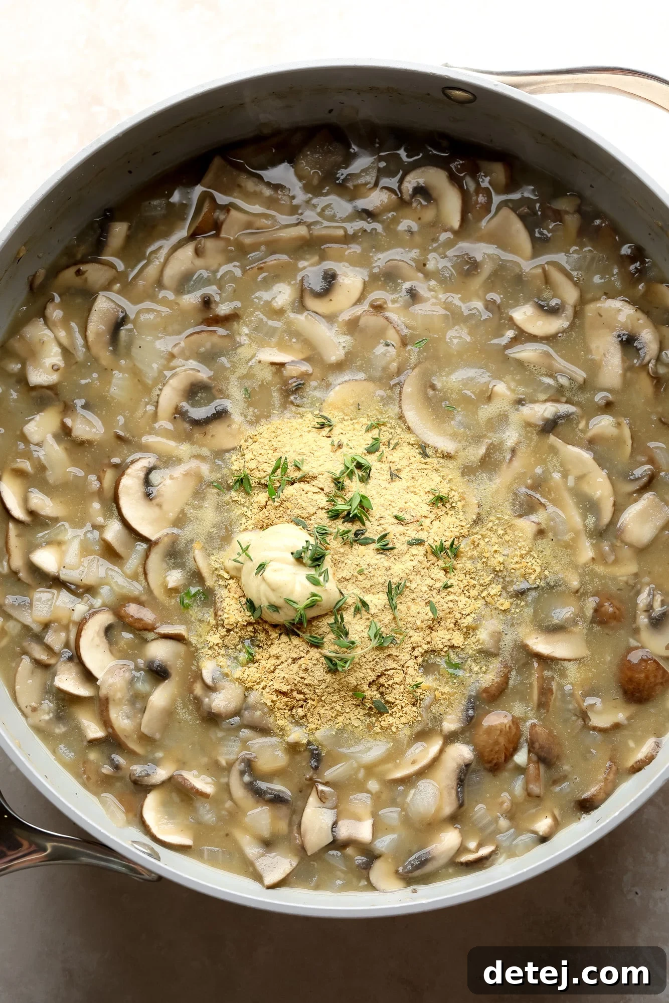 The rich mushroom gravy simmering in a large grey pot, thickening to perfection for the stroganoff.