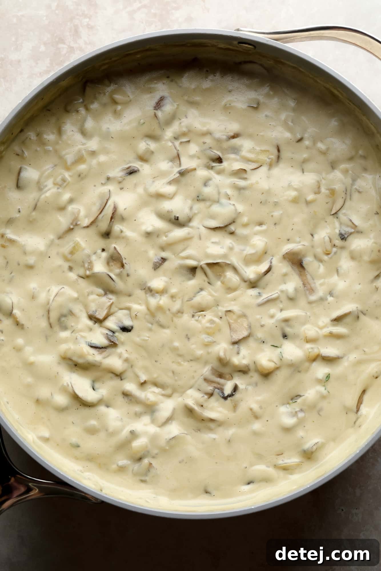A close-up of the fully cooked, rich, and creamy mushroom gravy in a large grey pot, ready for pasta.