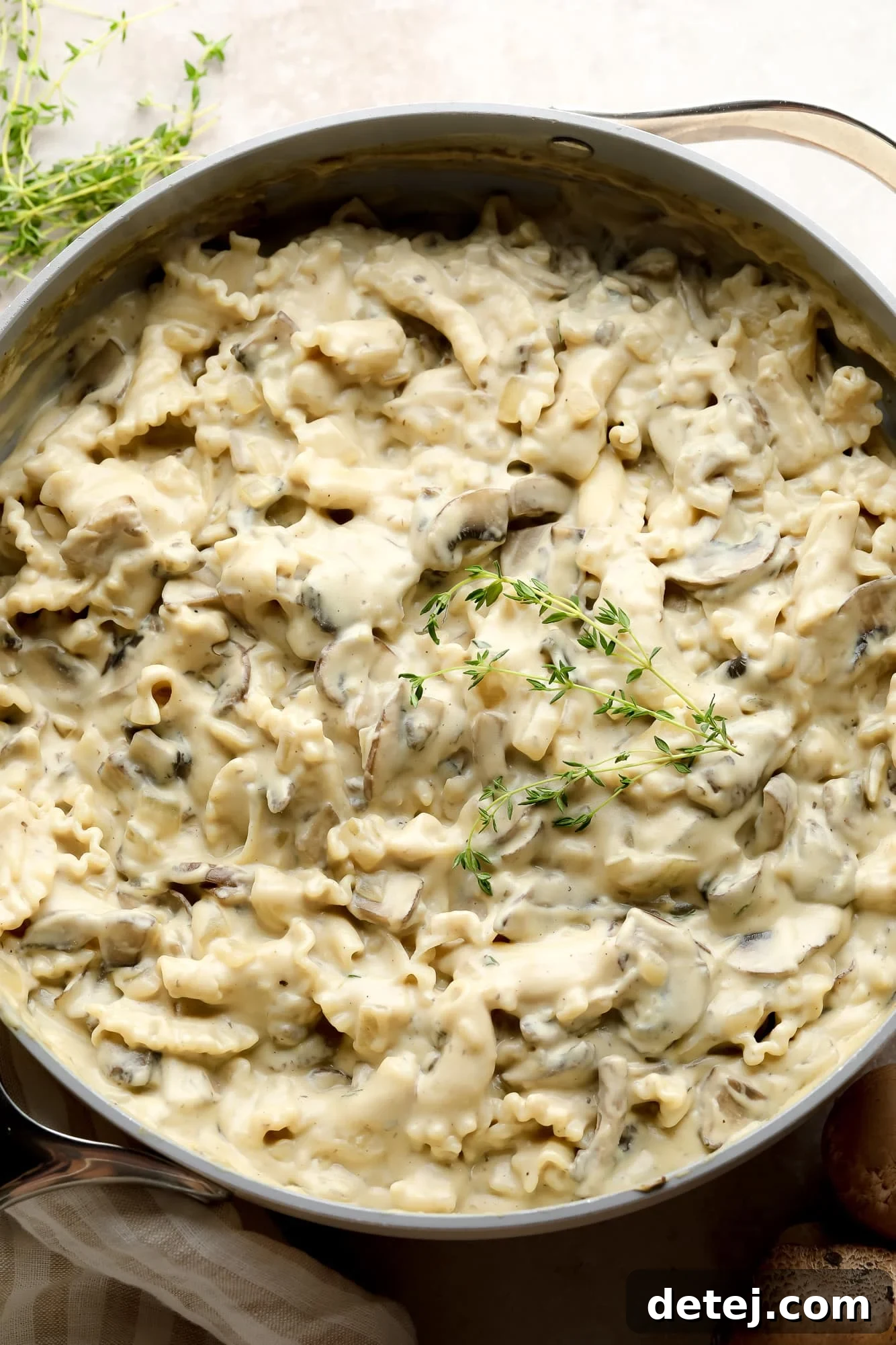 A large pot filled with creamy vegan mushroom stroganoff, beautifully plated and ready to be served, garnished with fresh herbs.