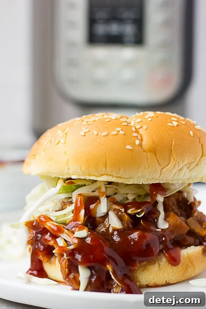 Üzerinde lahana salatası ile servis edilmiş Instant Pot'ta hazırlanmış çekme barbekü jackfruit sandviç.