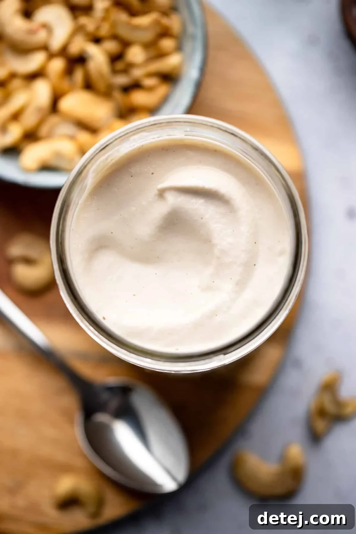 A beautifully textured jar of creamy cashew cream, ready for use as a dairy-free heavy cream substitute.