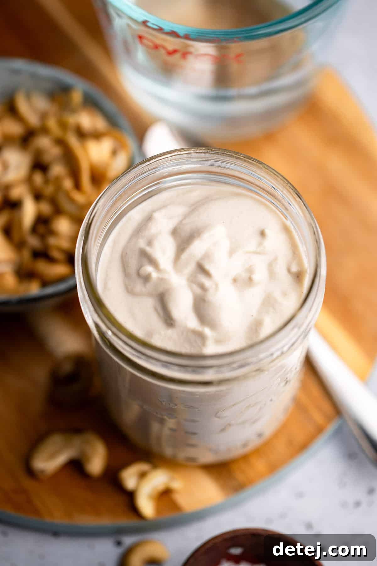 Close up on a pristine jar of homemade cashew cream, demonstrating its smooth and appealing texture.