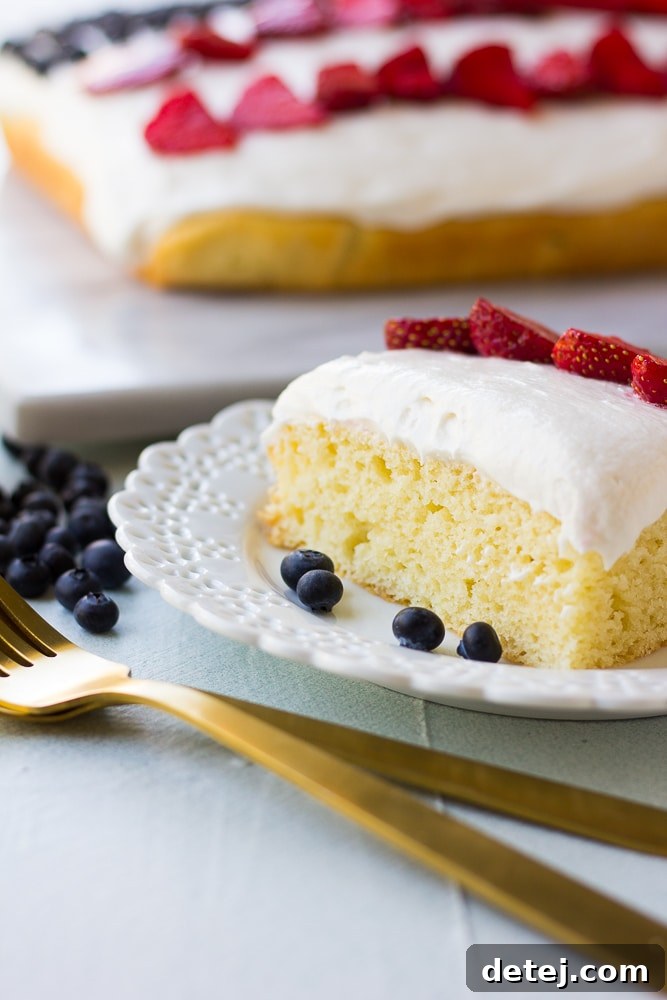 A perfect slice of the one-bowl vegan flag cake, showcasing the layers of cake, frosting, and berries.
