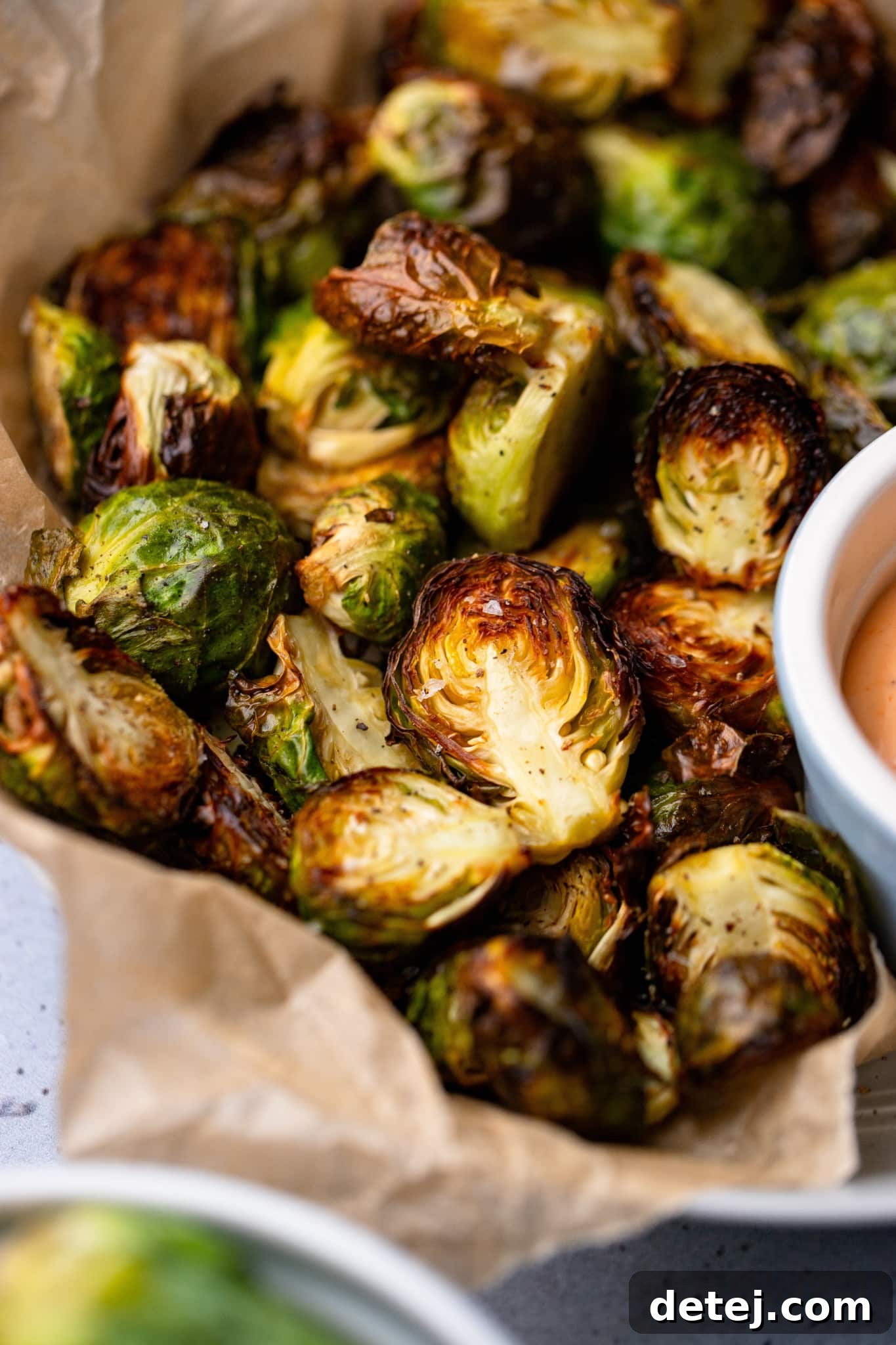 close up on cooked brussels sprouts in a serving bowl.