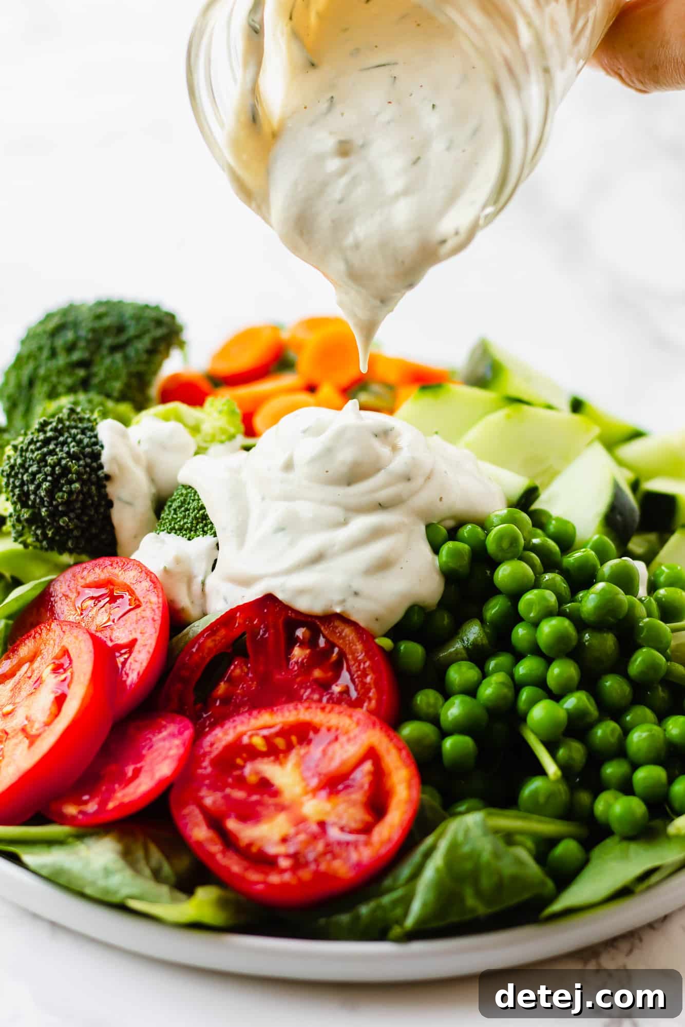 Vegan Ranch Dressing 2 pouring vegan ranch dressing over a large green salad.