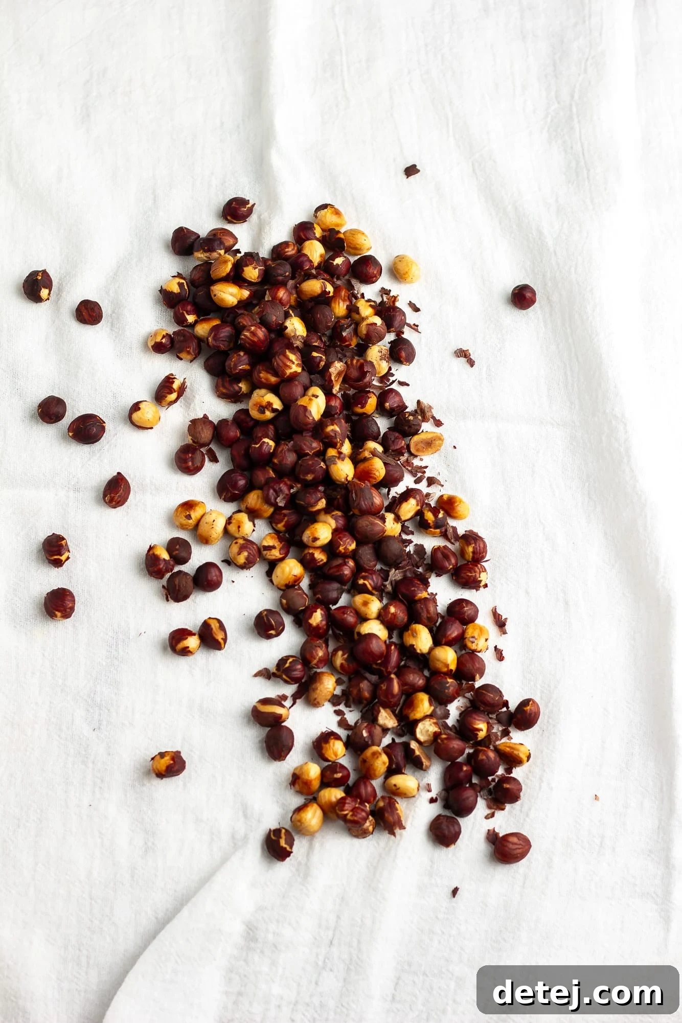 roasted hazelnuts on a white kitchen towel.