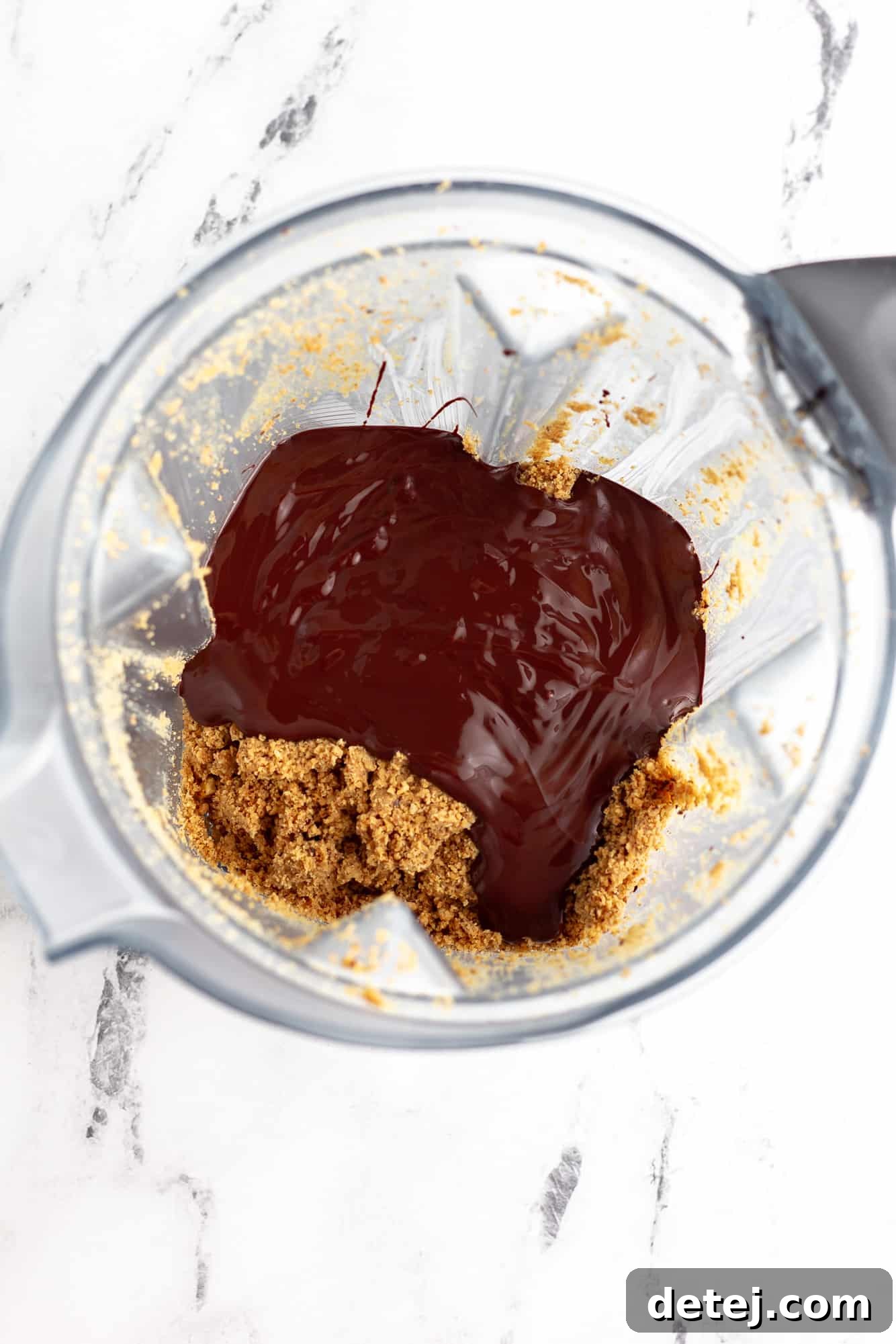 melted chocolate on top of blended hazelnut butter in a blender.