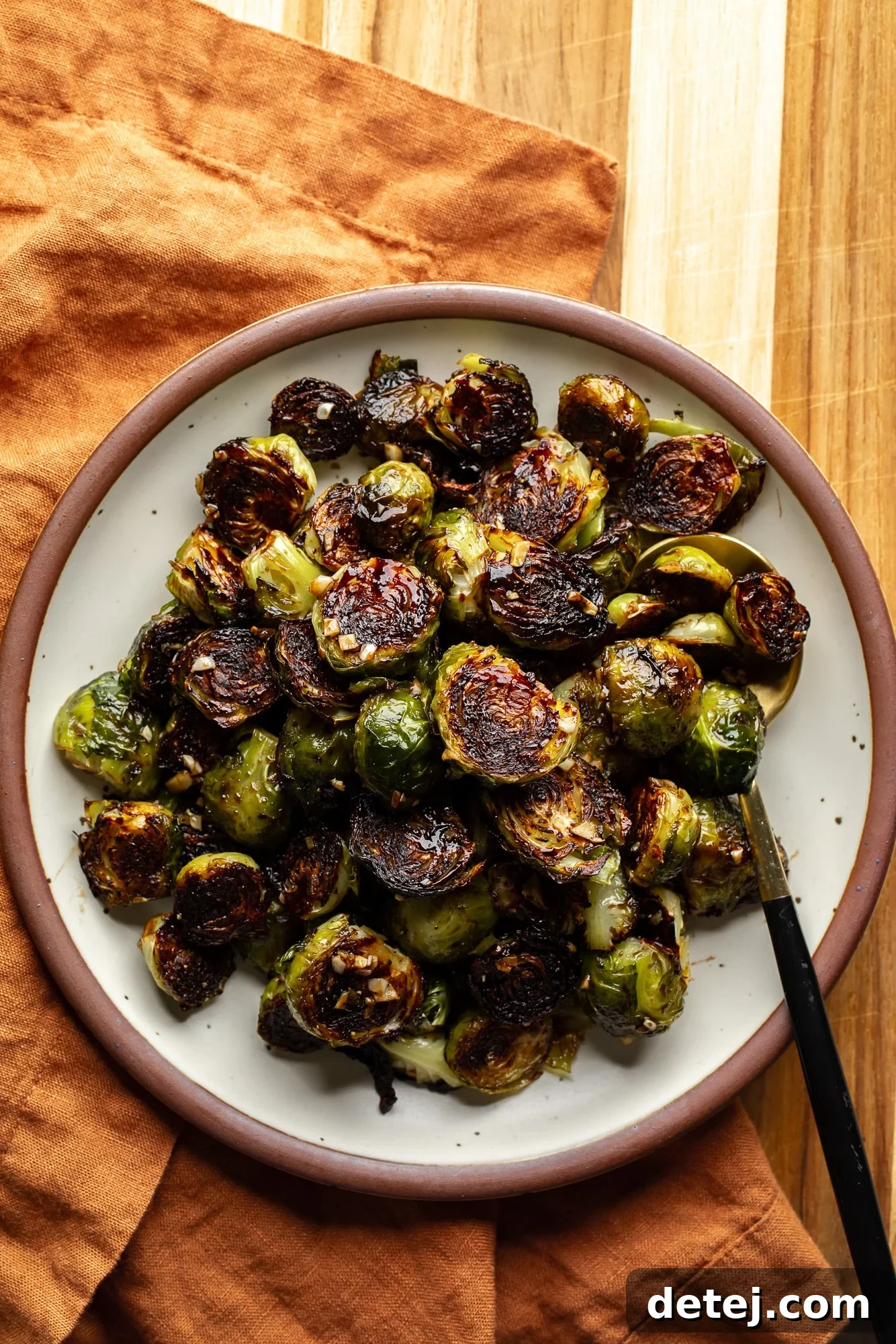 A rustic bowl overflowing with perfectly roasted Brussels sprouts, showcasing their diverse textures and rich, caramelized colors.