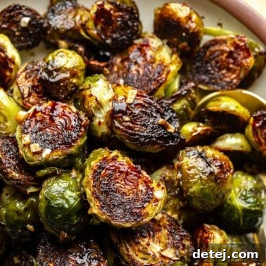 close up on a pile of roasted brussels sprouts with lightly charred edges.