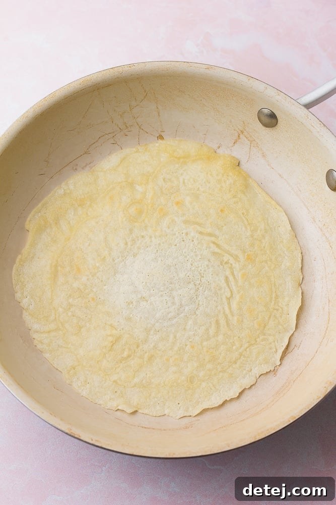 crepe in a pan flipped over cooking on second side
