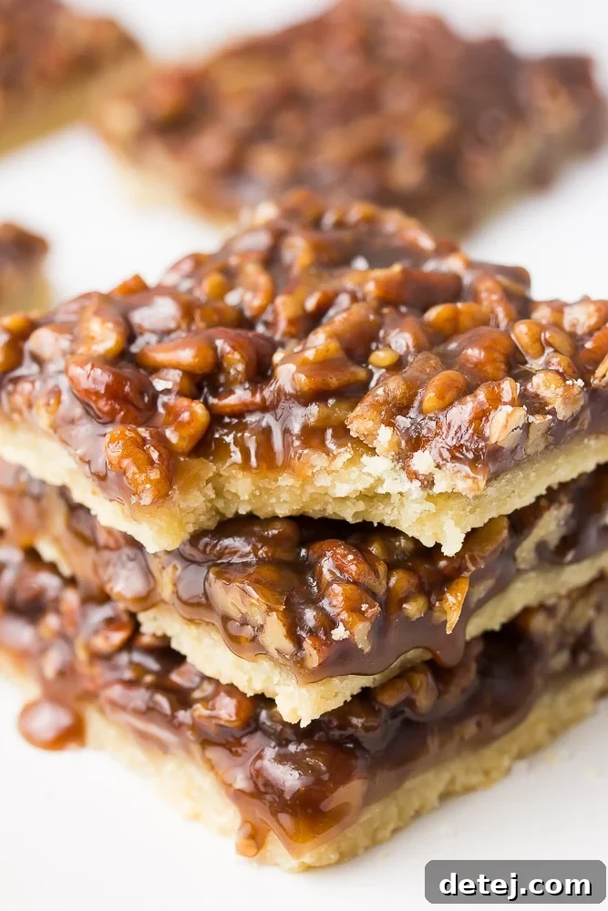 A perfectly portioned vegan pecan bar with a bite taken out, revealing the gooey caramel pecan filling and golden shortbread crust.