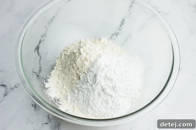 White flour and powdered sugar in a bowl, ready to be mixed for vegan shortbread.