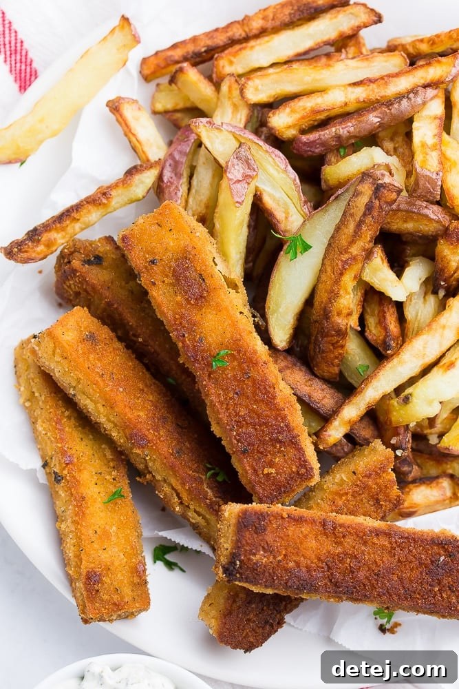 A plate of golden-brown tofu fish sticks served alongside crispy French fries.