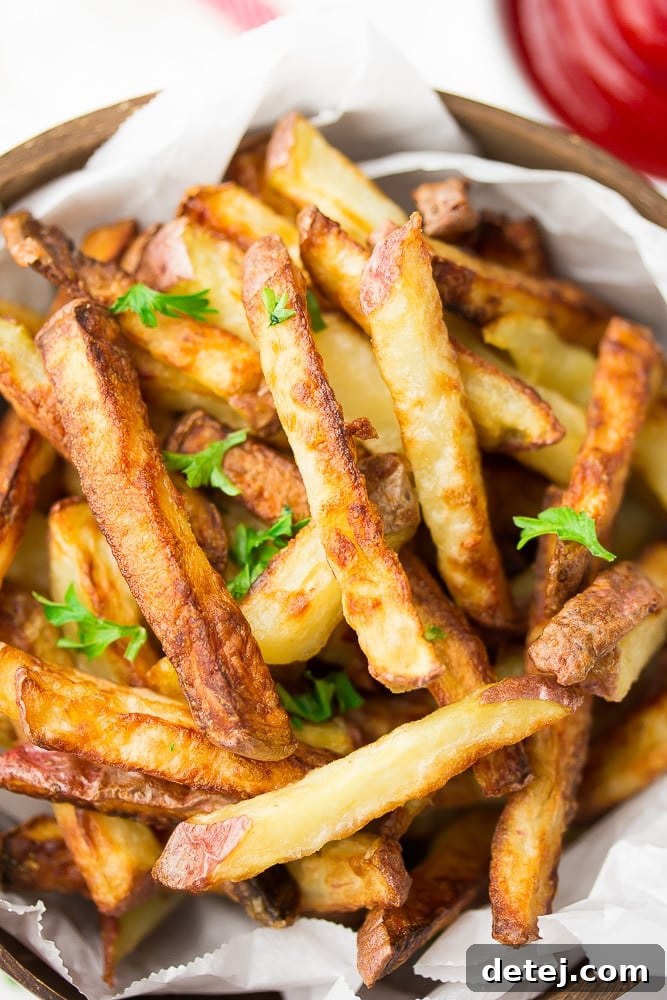 Crispy golden fries on a plate with fresh parsley, ready to be served