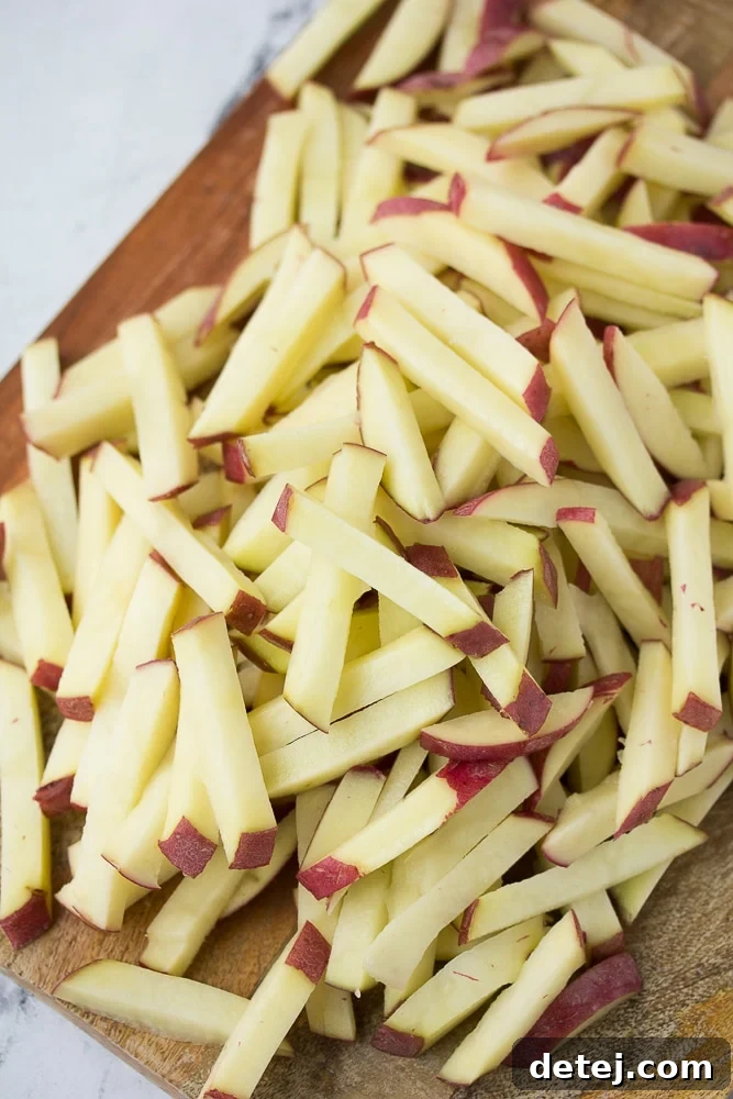 Pile of raw, hand-cut potatoes, prepped for making crispy air fryer fries