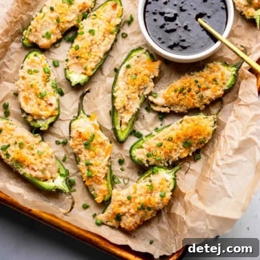 Vegan Jalapeno Poppers on a tray next to a small bowl of raspberry sauce.