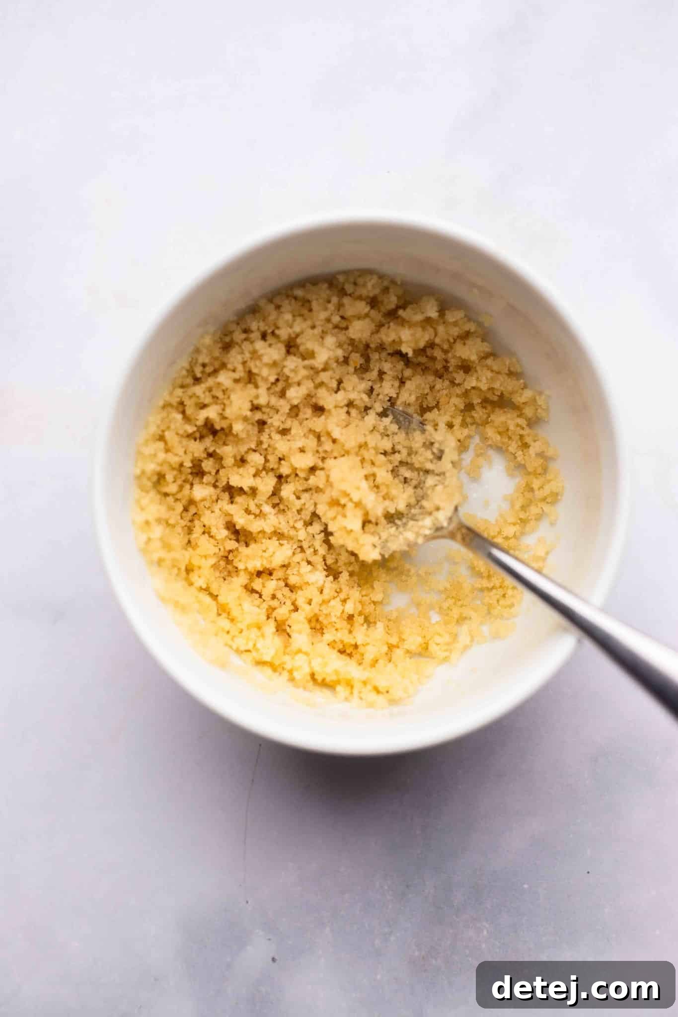 breadcrumbs and butter stirred together in a white bowl.