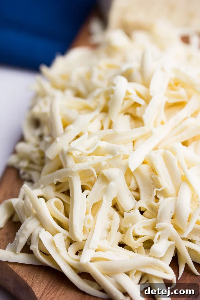 A close-up view of freshly shredded vegan mozzarella, showcasing its perfect texture and readiness for culinary use.