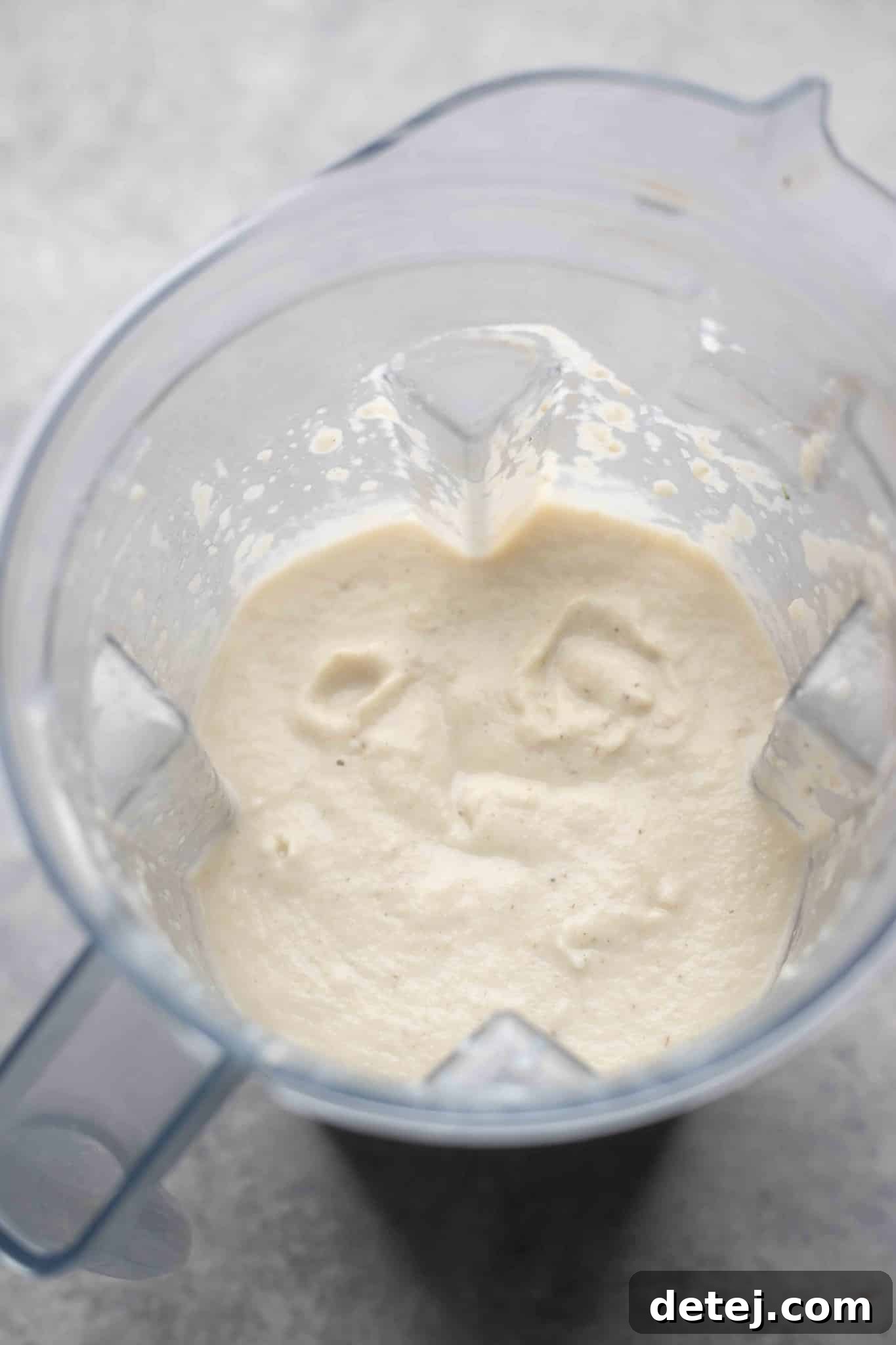 Creamy vegan cauliflower soup in a blender, perfectly smooth and ready to be returned to the pot.