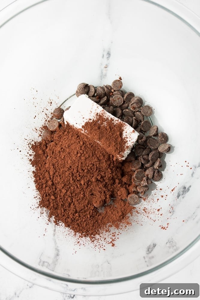 Vegan butter, cocoa powder, and chocolate chips melting in a bowl