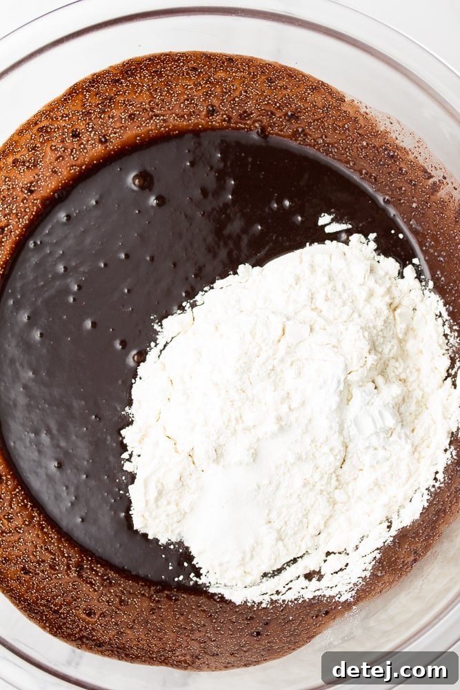 Flour being added to the chocolate mixture in a bowl