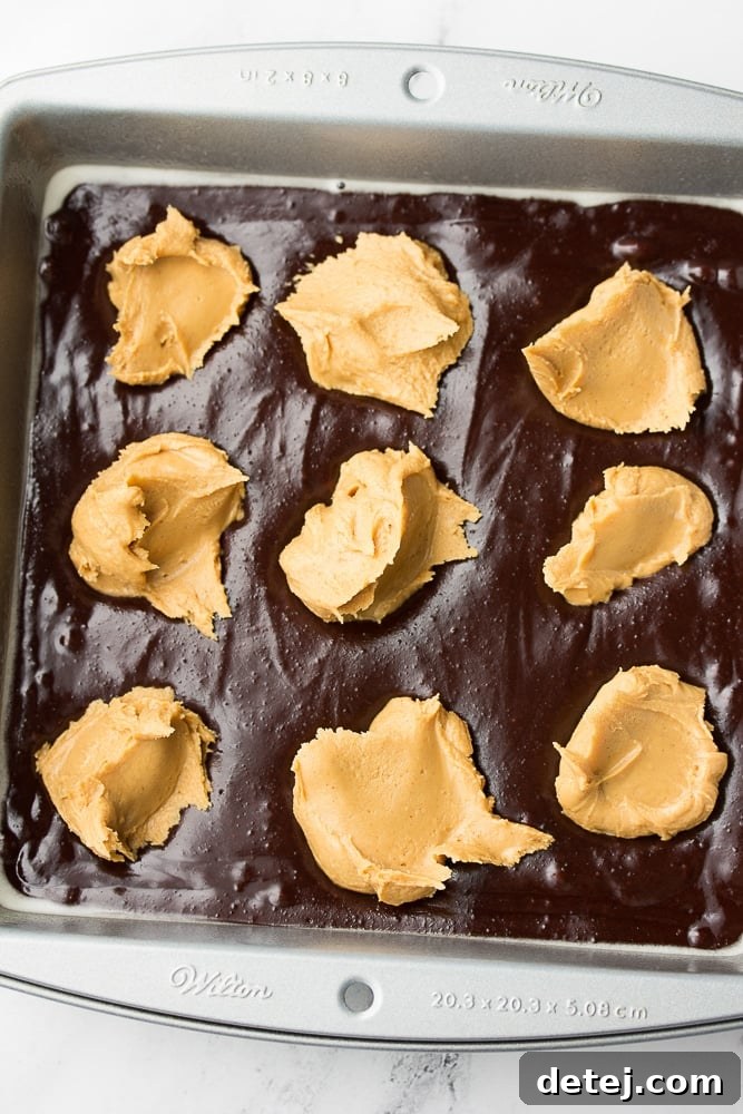 Dollops of peanut butter mixture on top of brownie batter