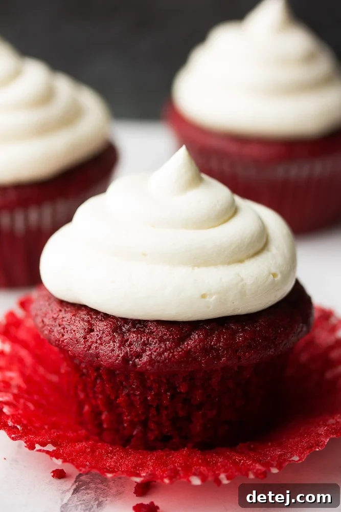 unwrapped red velvet cupcakes with more in back, perfectly frosted