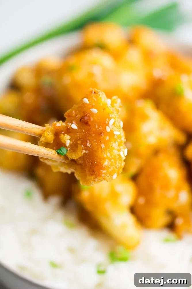 Sunset Cauliflower 5 chopsticks holding a piece of cauliflower in sauce