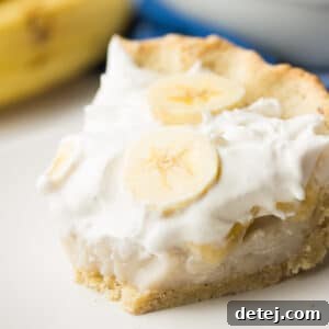 Square image of creamy pie with bananas and a bite taken out of it