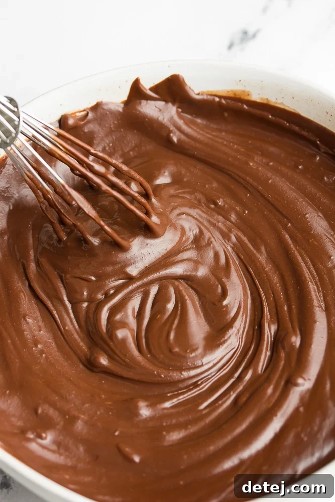 bowl with creamy, melted vegan chocolate ganache and a whisk, ready for use