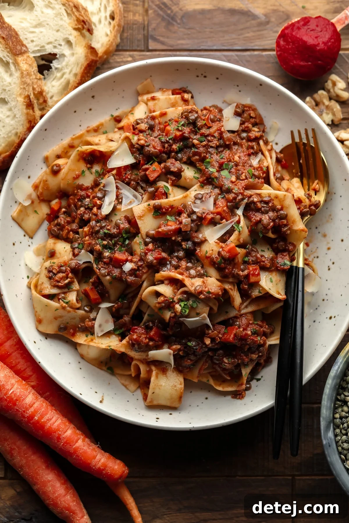 bowl with pasta and lentils, bread, carrots and lentils around it