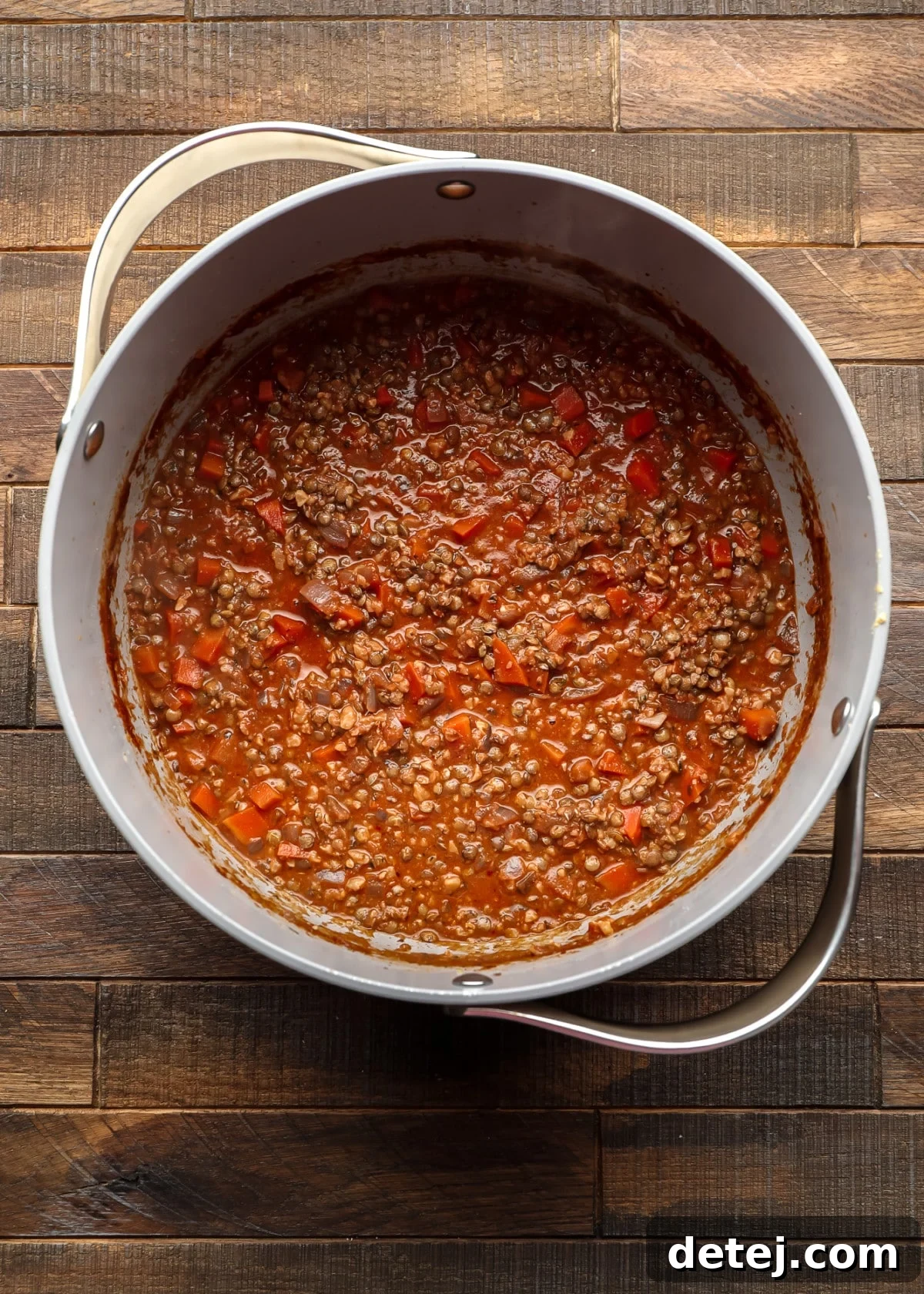 lentils and carrots in a reddish sauce in a pot
