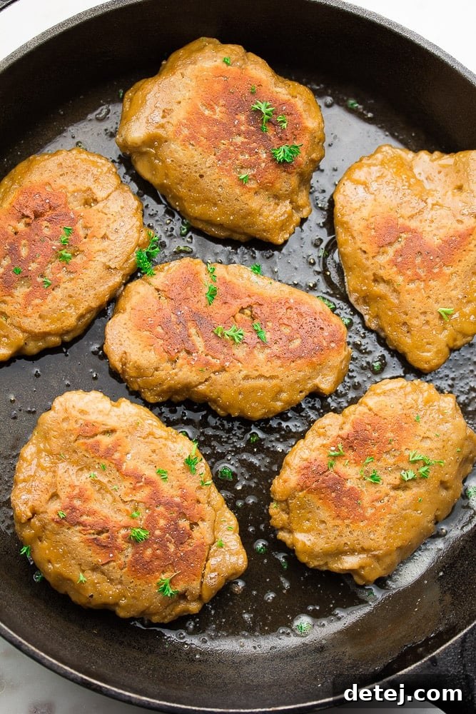 Plant-Based Chicken 3 Close-up shot of perfectly cooked vegan "chicken" pieces sizzling in a cast iron pan, ready to be served or added to a delicious meal.