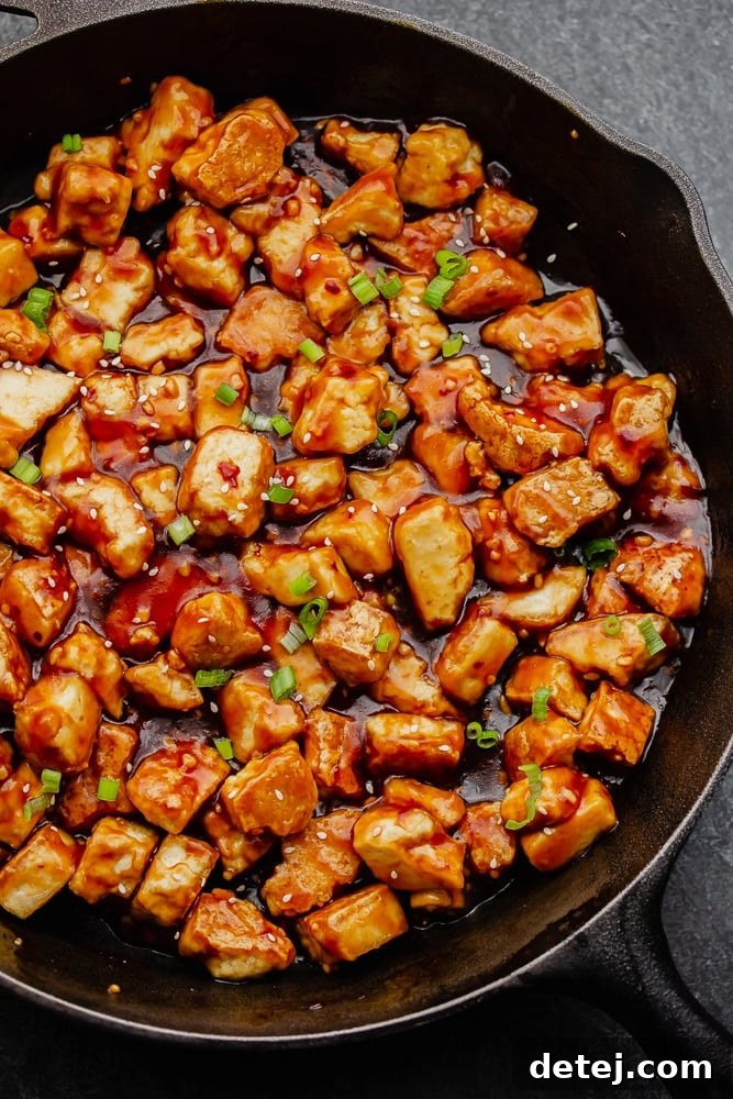 Cooked General Tso's Tofu coated in sauce in a large pan, ready to be served.